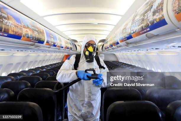 Yair Badash, a maintenance manager at the Israeli low-cost ariline Israir, wears his PPE as he disinfects an aircraft between flights at Ben Gurion...