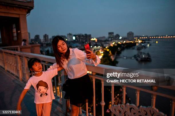 Woman takes a selfie picture on Wuhan Bridge over Yangtze River in Wuhan in China's central Hubei province, on July 14, 2020. - Various parts of...