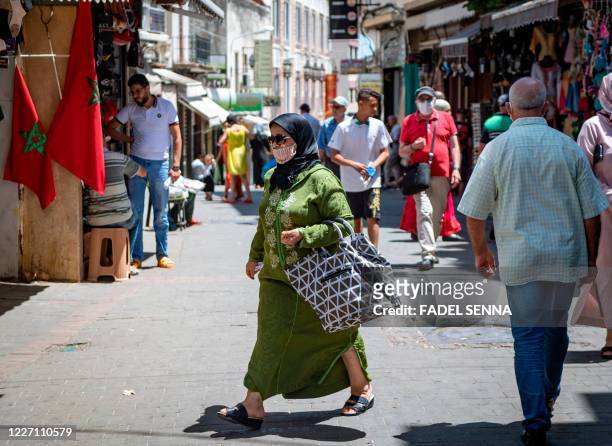 Moroccan woman, wearing a protective face mask, walks in a street in Tangiers' Old City on June 14 after the announcement of lockdown measures in the...