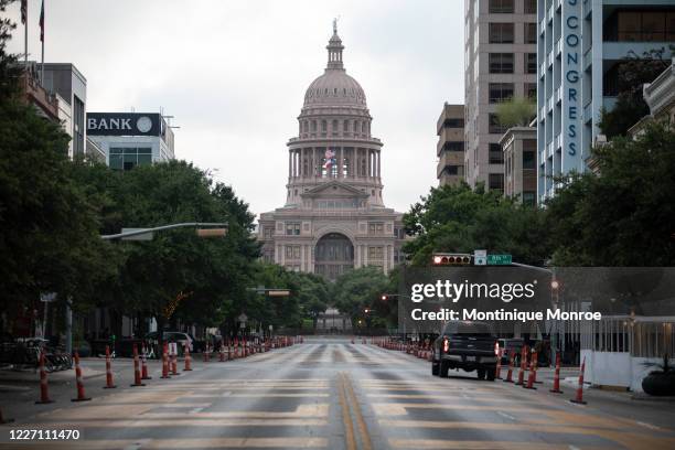 Cars drive on Congress Avenue in front of the Texas Capitol building on July 2020 in Austin, Texas. Austin public health officials reported 657 new...