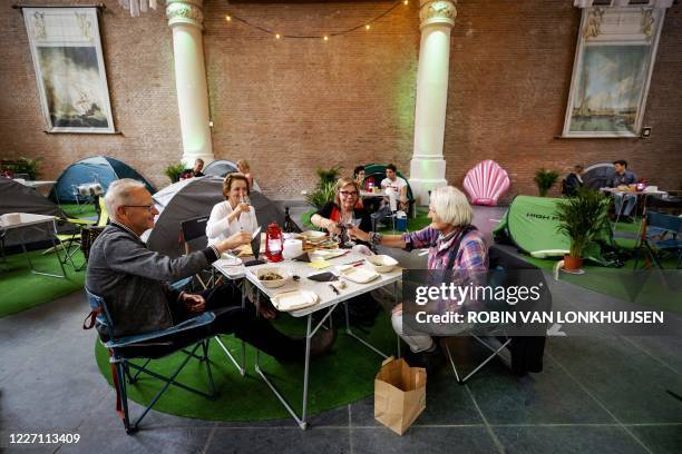 Guests sits in front of their tents in the Sint Olofs Chapel in Amsterdam on July 14 during the Camping at Olofs, a former church in the Zeedijk...
