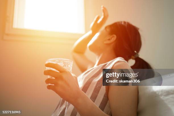 asian female thirsty and dehydration drinking fresh water at summer season at home - sizzling photos et images de collection