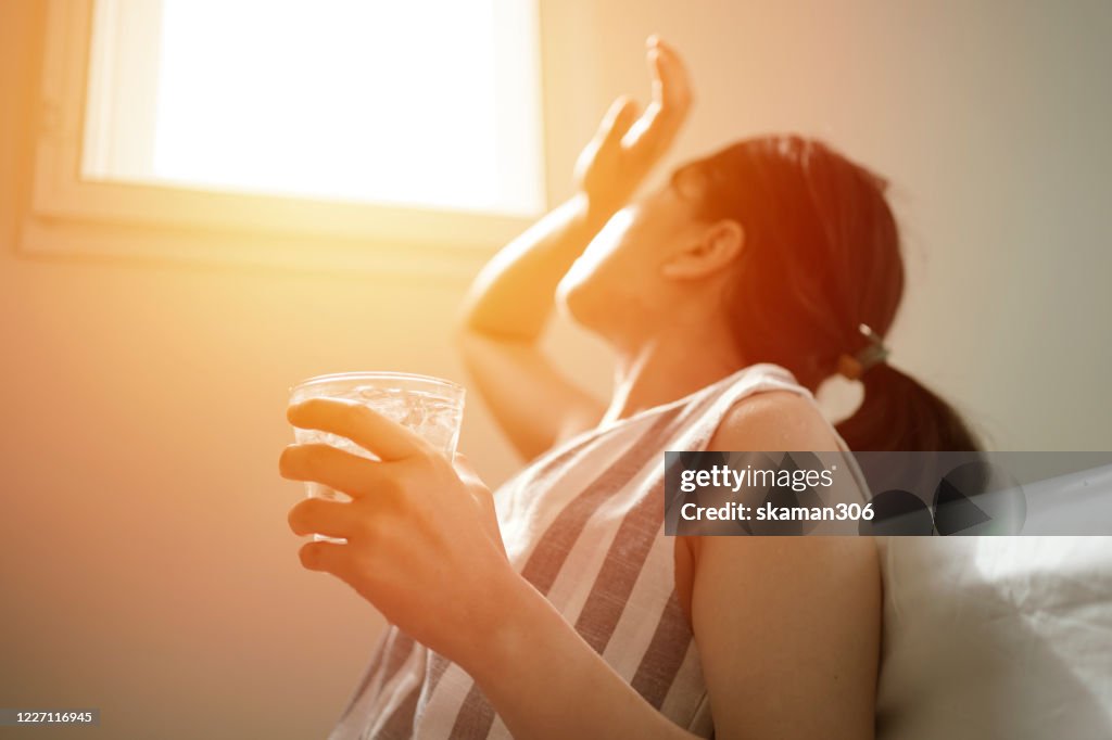 Asian female thirsty and dehydration drinking fresh water at summer season at home
