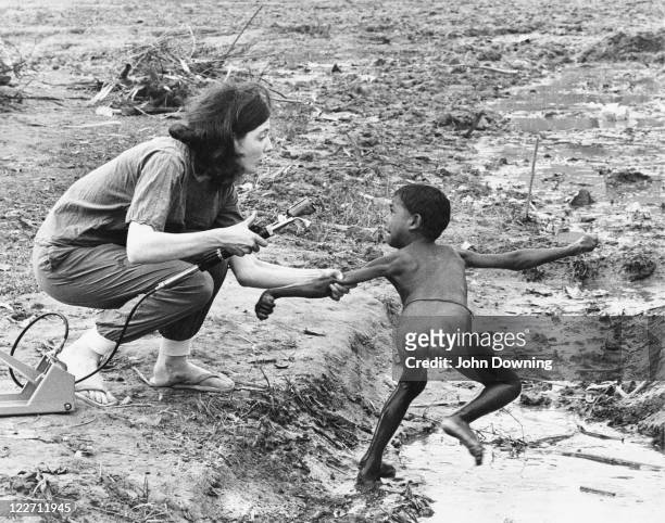 Nurse from the British charity War on Want attempts to vaccinate a terrified boy against cholera during an outbreak of the disease at a refugee camp...