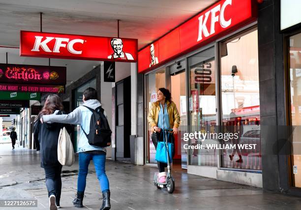 Person walks past a KFC outlet in Melbourne's central business district on July 15, 2020. - Australians under lockdown for the second time are...