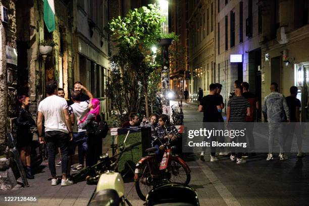 Customers stand in the street outside a 'ruin' bar in the seventh district of Budapest, Hungary, on Saturday, July 11, 2020. Budapest is preparing to...