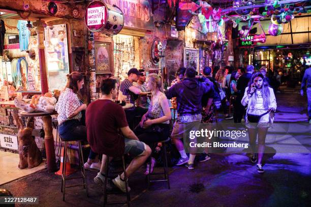 Customers sit at tables outside a 'ruin' bar in the seventh district of Budapest, Hungary, on Saturday, July 11, 2020. Budapest is preparing to...