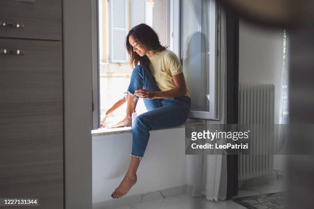 beautiful woman taking her of herself in a relaxed morning at home - black painted toes stock pictures, royalty-free photos & images