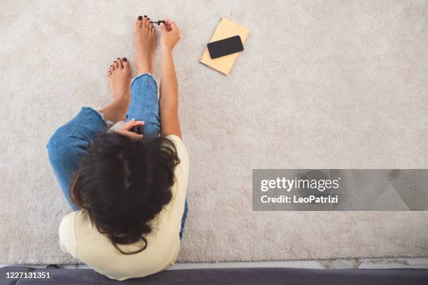 beautiful woman taking her of herself in a relaxed morning at home - black painted toes stock pictures, royalty-free photos & images