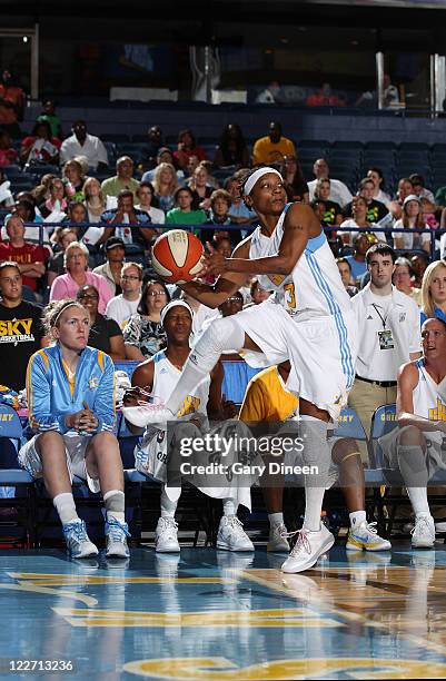 Dominique Canty of the Chicago Sky keeps the ball in play as teammates Carolyn Swords, Michelle Snow, and Cathrine Kraayeveld watch from the bench...