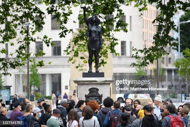 People gather to view a new sculpture, by local artist Marc Quinn, of Black Lives Matter protestor Jen Reid on the plinth where the Edward Colston...