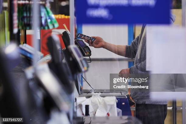 Custumer makes a smartphone electronic payment at a self-service check-out counter in a Tesco Plc supermarket in Wroclaw, Poland, on Tuesday, July...