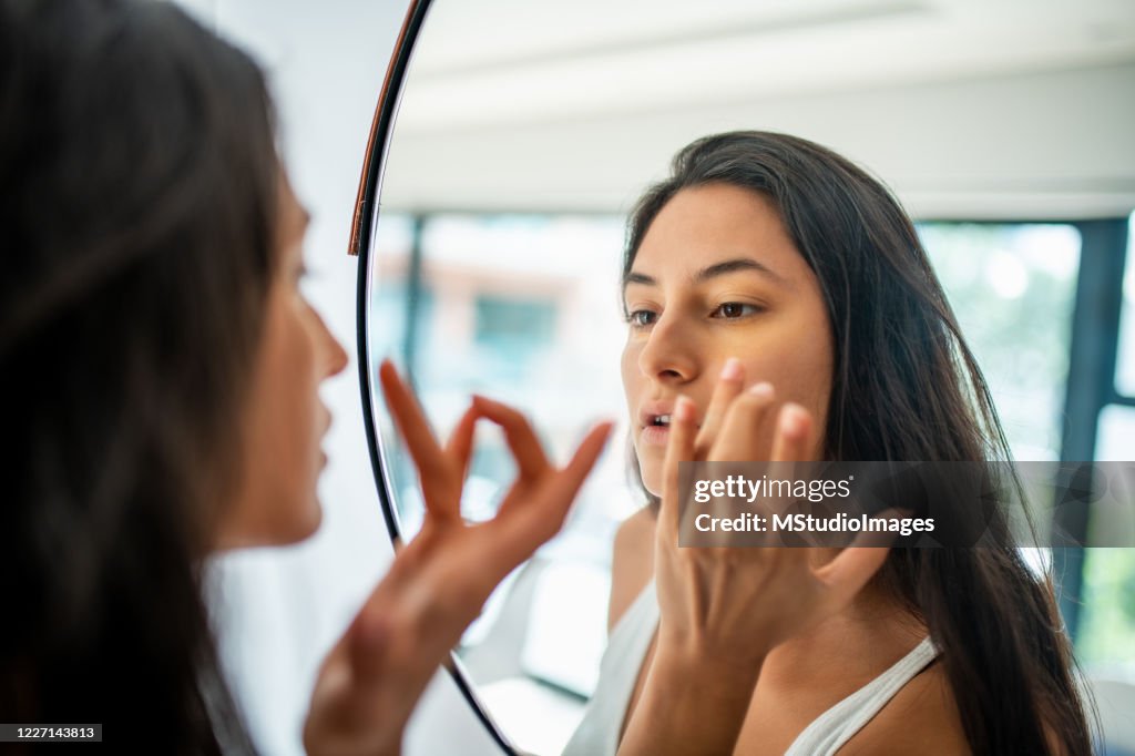 Young Latin woman putting make up.