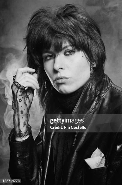 Chrissie Hynde, US singer and guitarist with rock band The Pretenders, wearing black lace fingerless gloves and a black leather jacket in a studio...