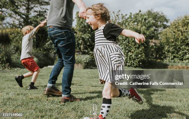 kids running in a garden - familia con dos hijos fotografías e imágenes de stock