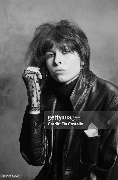 Chrissie Hynde, US singer and guitarist with rock band The Pretenders, wearing black lace fingerless gloves and a black leather jacket in a studio...