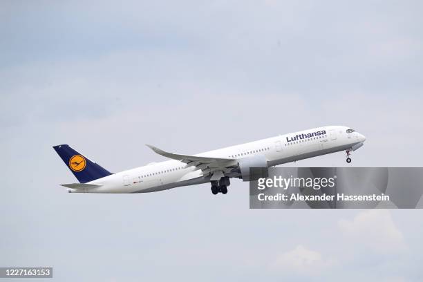 Passenger plane Airbus A 350 941 of German airline Lufthansa is airborne at Munich Franz-Josef-Strauss International Airport during the coronavirus...