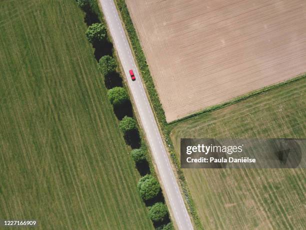 aerial top down of landscape with red car. - car aerial view stock pictures, royalty-free photos & images