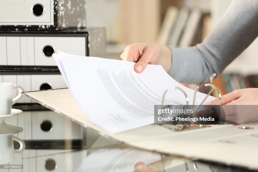Woman hands organizing putting files on folder