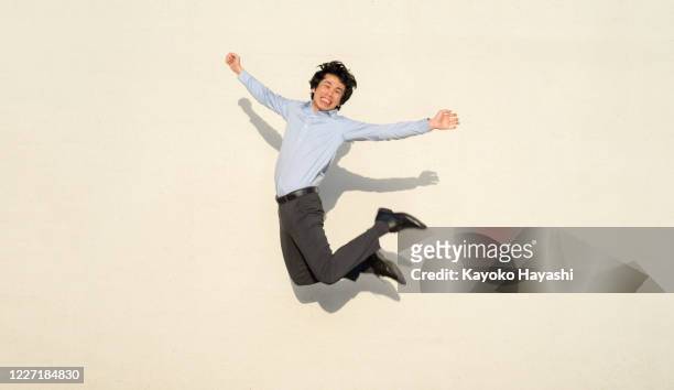 幸せな男は全身ジャンプで喜びを表現する - joy ストックフォトと画像