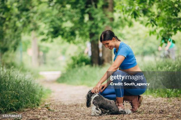 fit woman with her dog in park - muscular dog stock pictures, royalty-free photos & images