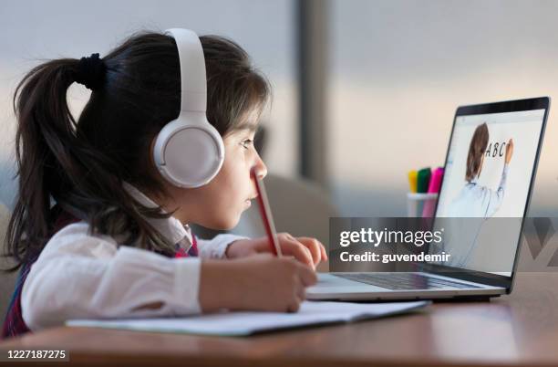 little girl attending to online school class - girls learning online imagens e fotografias de stock
