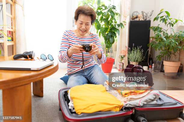 senior woman preparing for holiday - break away from pack technology stock pictures, royalty-free photos & images