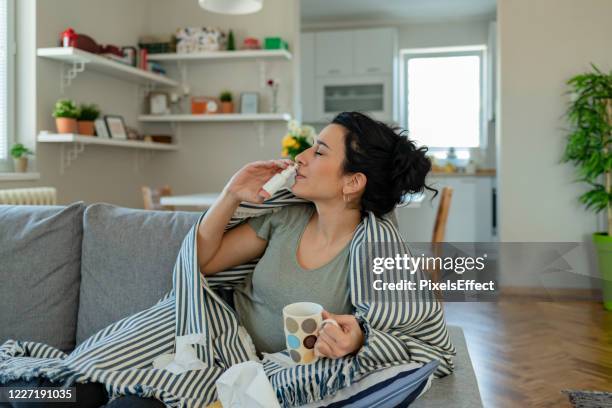 woman using nasal spray - caucasian woman sick in bed coughing stock pictures, royalty-free photos & images