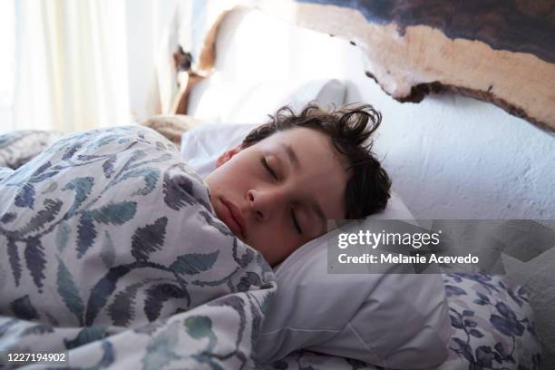 adolescent boy asleep in bed, just his head showing above the covers. - boy asleep in bed bildbanksfoton och bilder