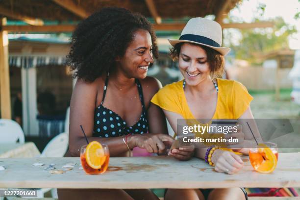 happy women on beach holiday shopping online - beach cocktail stock pictures, royalty-free photos & images