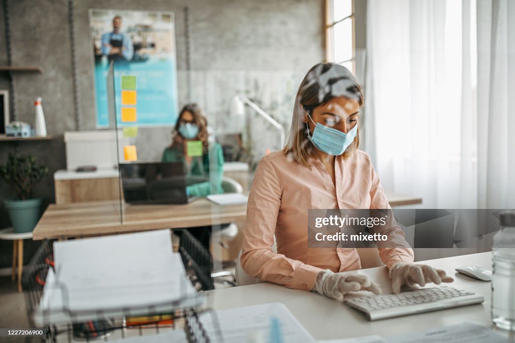 Business colleagues working at office by maintaining social distance