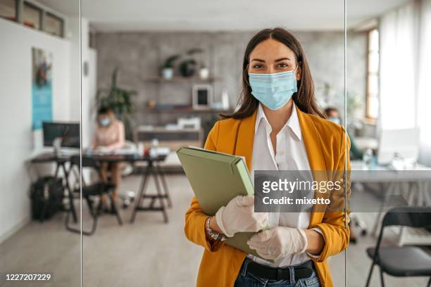 businesswoman with protective gloves and face mask at office - corporate business covid stock pictures, royalty-free photos & images