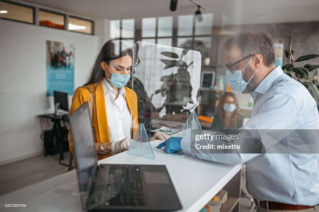 Bank teller talking with customer at counter