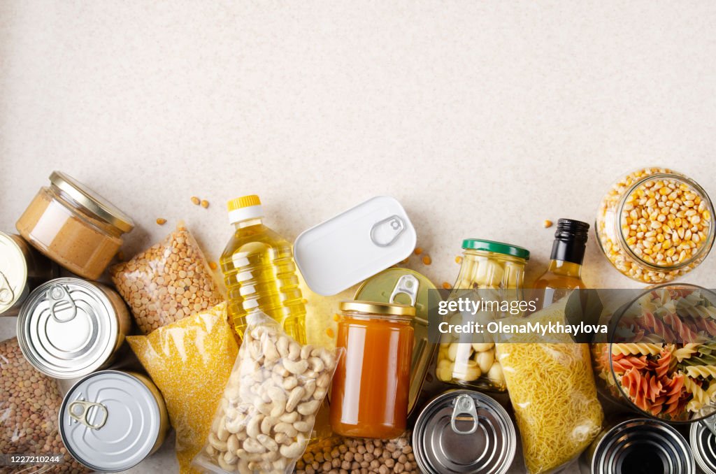Flat lay view at kitchen table full with non-perishable foods. Spase for text