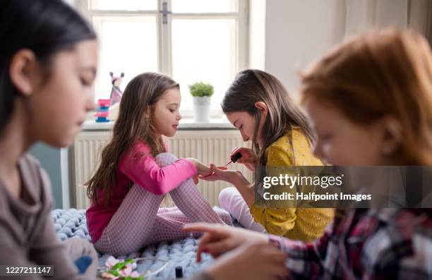 group of small girl friends sitting on bed, painting nails. - 4 girls finger painting bildbanksfoton och bilder