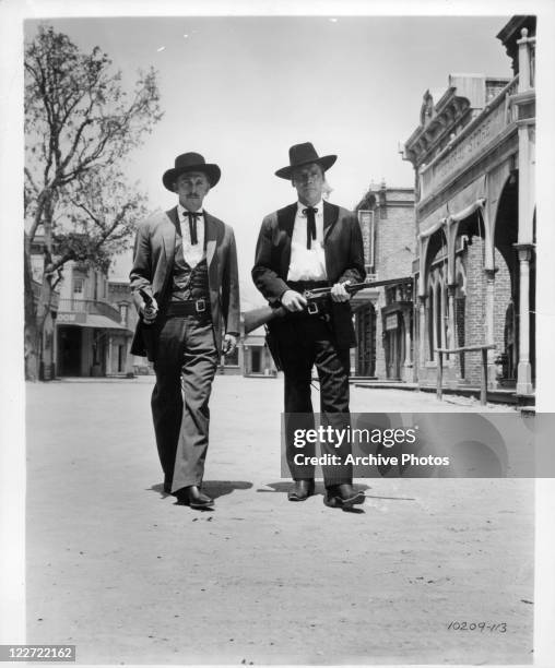 Kirk Douglas And Burt Lancaster walk with gun drawn in a scene from the film 'Gunfight At The O.K. Corral', 1957.