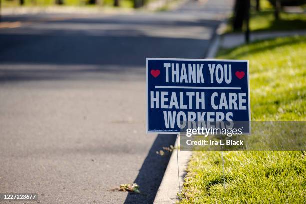 Sign on a lawn says, "Thank You Health Care Workers" with hearts on the sign. On April 24 cases in New Jersey surpass 100,000 and is now the 2nd...