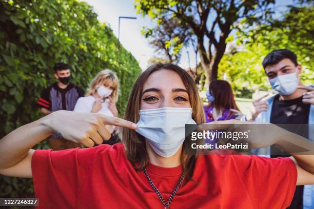 gruppo di adolescenti in posa mostrando le loro maschere protettive per il viso - cultura della gioventù foto e immagini stock