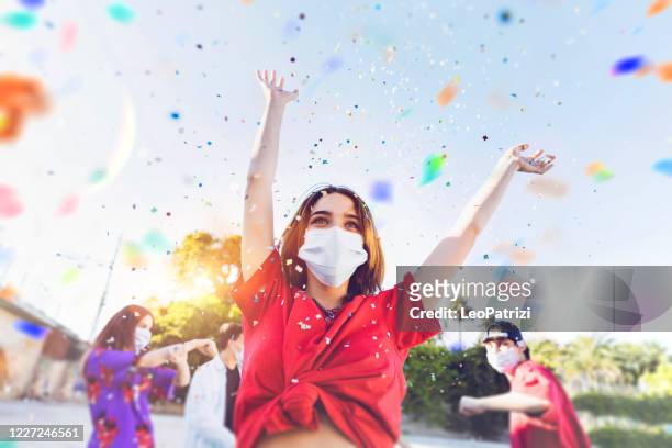 grupo de adolescentes celebrando en una fiesta con máscaras faciales - celebration fotografías e imágenes de stock