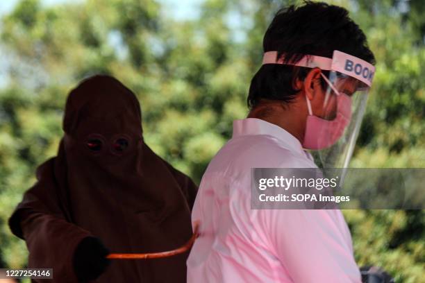 The executioner seen whipping a man wearing a face shield for violating Islamic Sharia law in North Aceh District. Islamic Sharia Court in North Aceh...