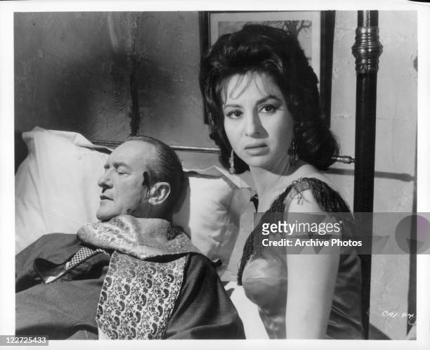 George Sanders seeks help at the house of dancing girl Faten Hamama after being wounded in a scene from the film 'Cairo', 1963.