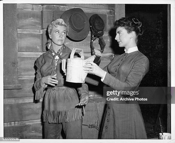 Doris Day Allyn McLerie can transform a dirty and barren cabin into a charmingly furnished cottage in a scene from the film 'Calamity Jane', 1953.