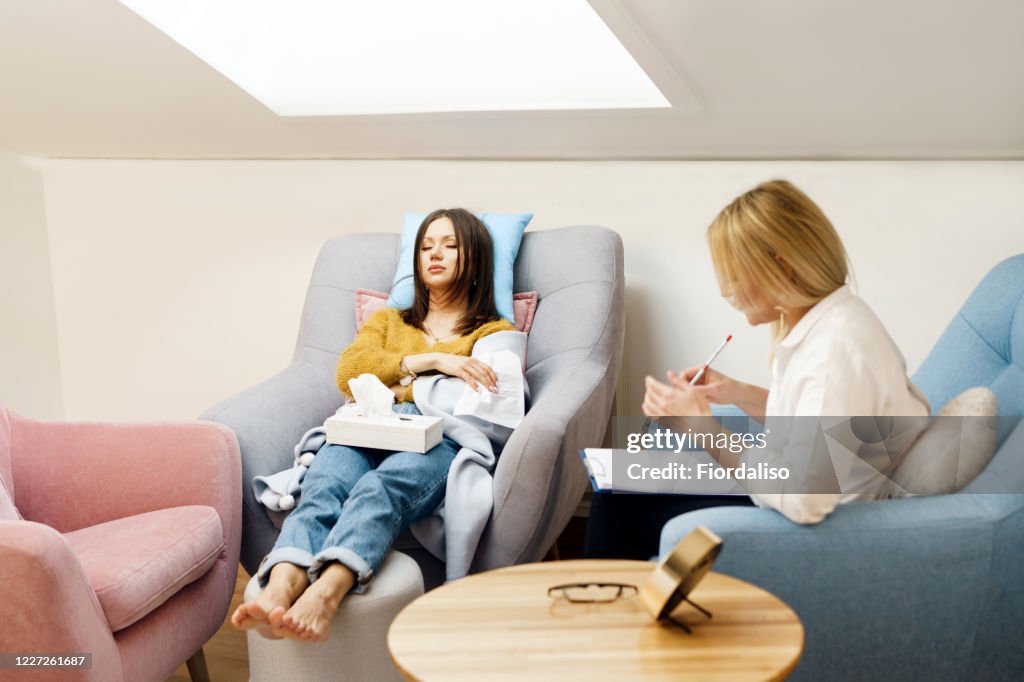 Woman psychologist talking to patient girl.