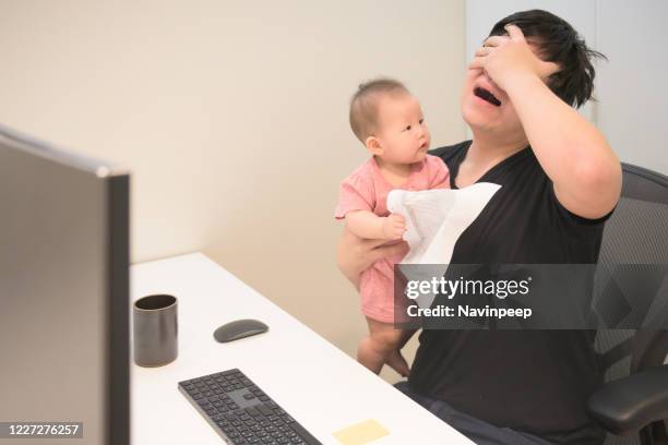 asian dad working at home, while baby daughter mess up his paper work - baby boot stock-fotos und bilder