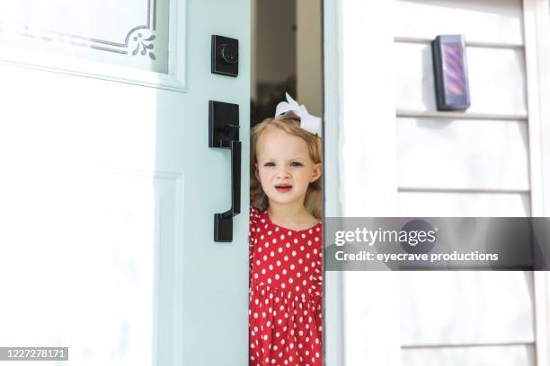 leuk blond meisje kind dat op iemand wacht om bij de ingang van het huisvoorgang aan te komen - girl doorbell stockfoto's en -beelden