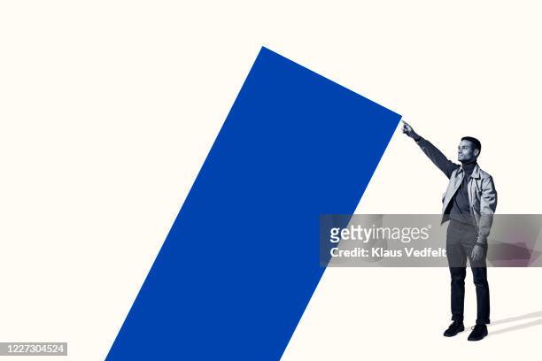 confident young man holding large blue bar graph - muster point stock pictures, royalty-free photos & images