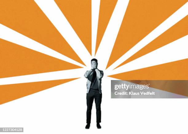 depressed man covering face amidst orange rays - pregiudizio foto e immagini stock