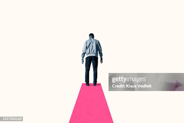 rear view of young man standing on pink footpath - weggucken stock-fotos und bilder