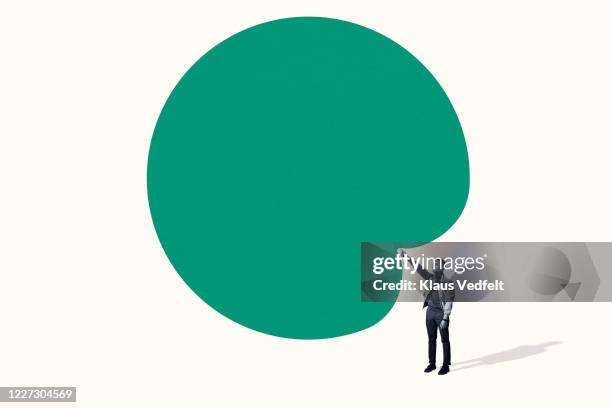 confident young man poking large green blob - bubble burst ストックフォトと画像