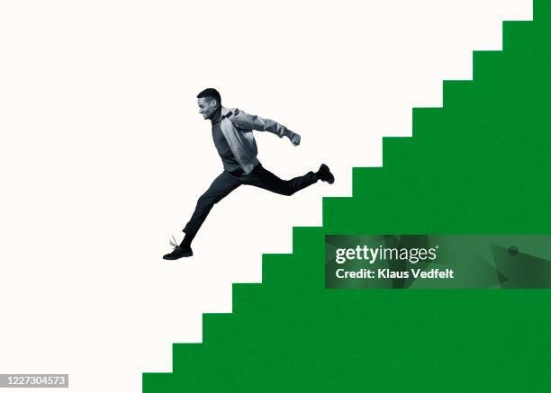 happy young man moving down on green steps - man jumping up and down fotografías e imágenes de stock